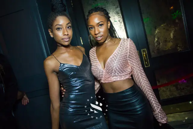Two women posing in a nightclub