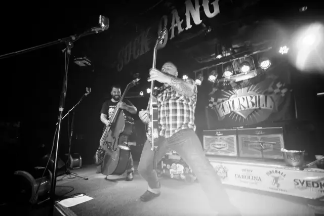 Black and white photo of a band playing live with an upright bass