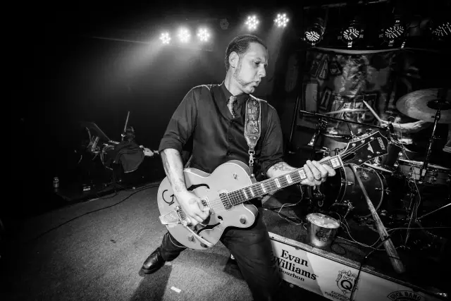 Black and white photo of a guitarist playing on stage