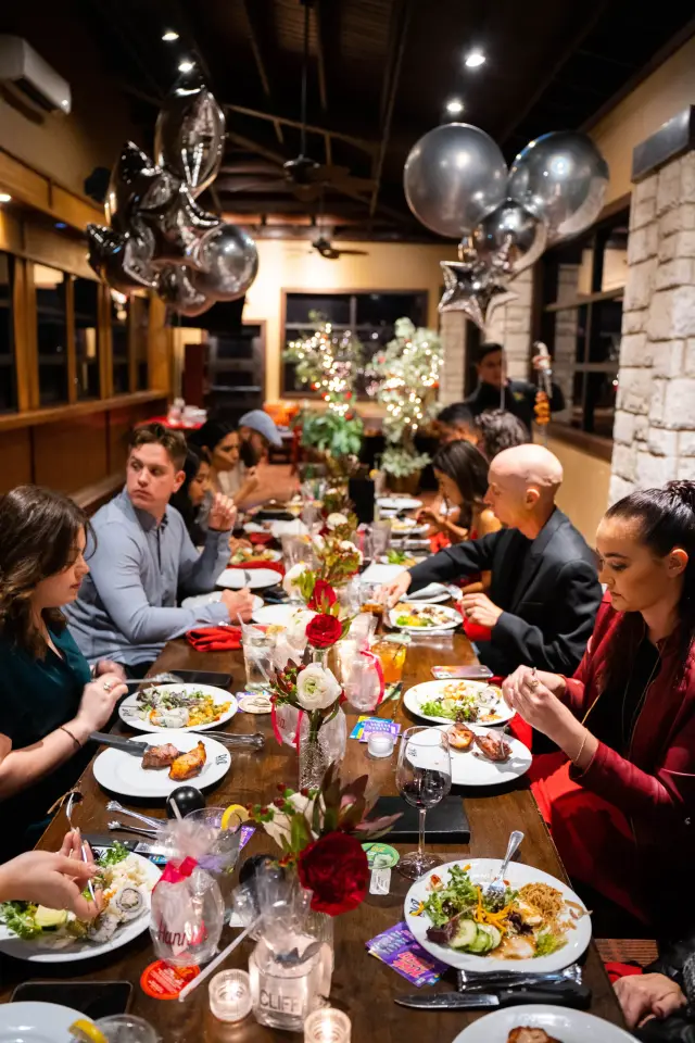 Guests at a long dinner table during a holiday party