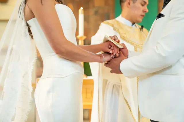 Bride and groom joining hands at the altar during a church wedding ceremony